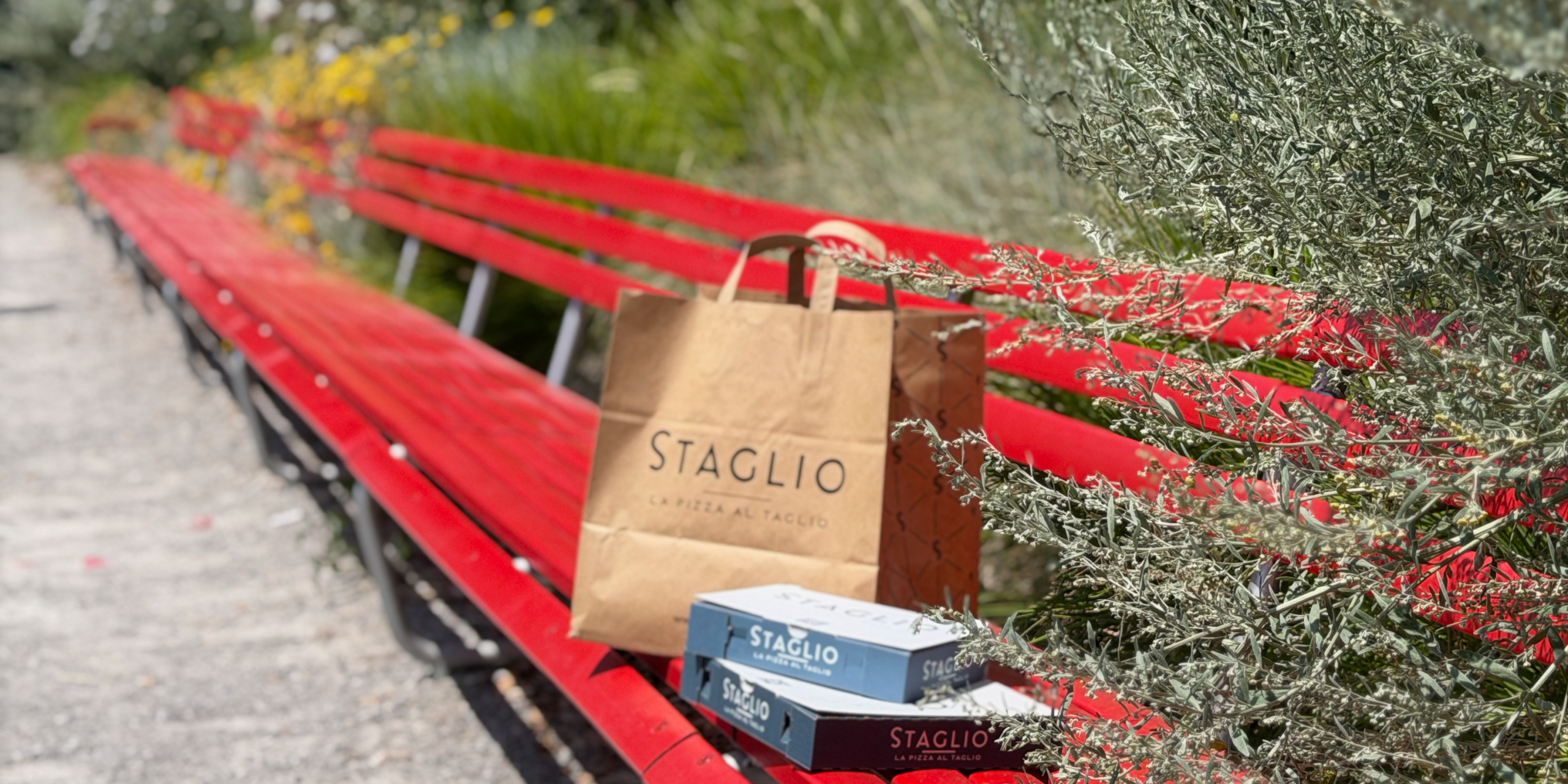La pizza di staglio su una classica panchina rossa di Lugano La pizza di staglio su una classica panchina rossa di Lugano